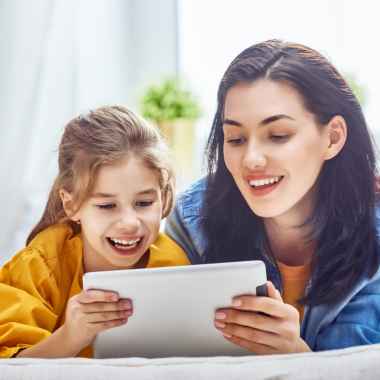 mom and girl smiling and using the ipad